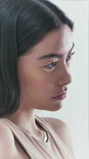Face of a model with jewelry posing in a photoshoot.